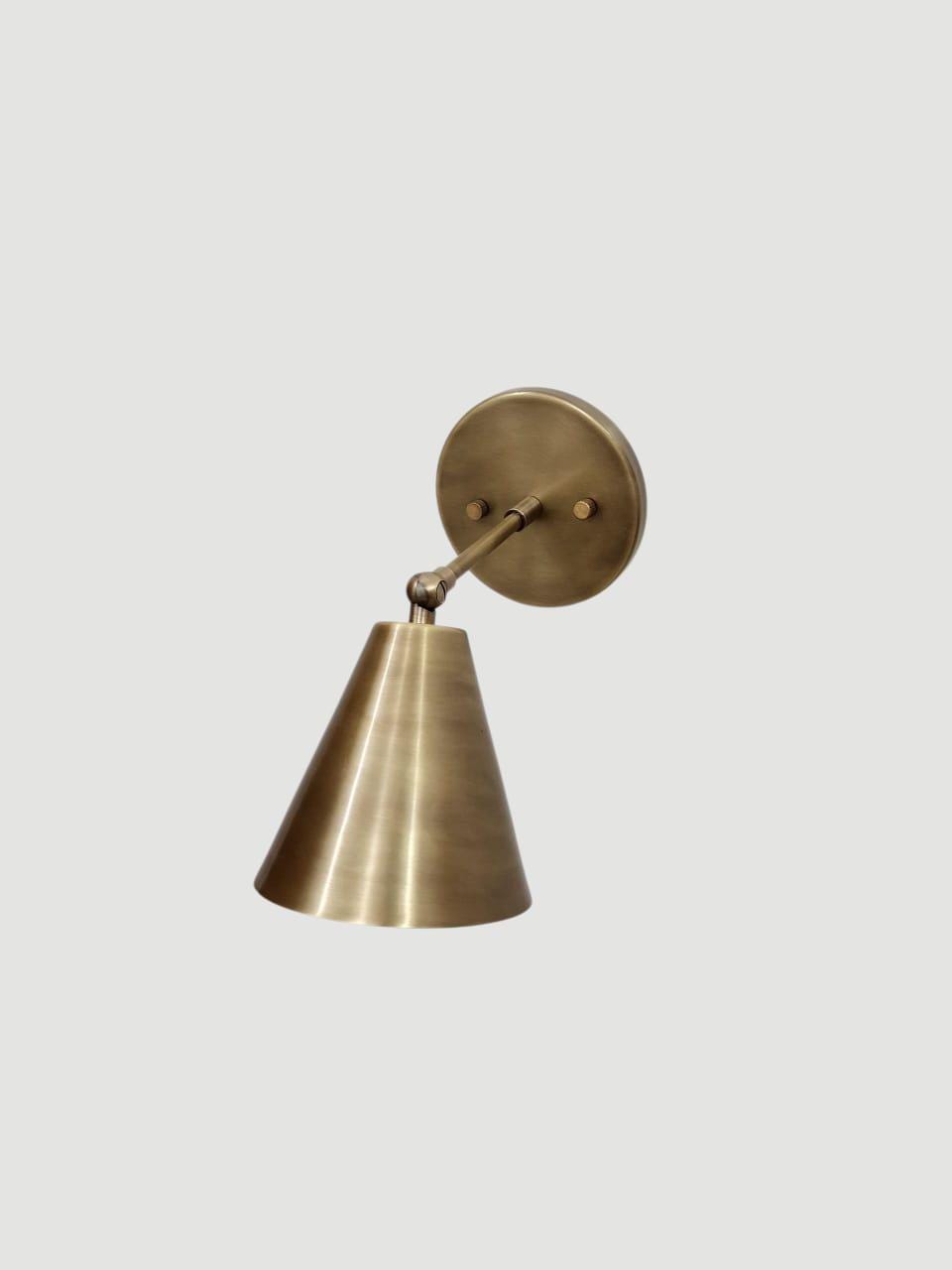 Brass adjustable wall sconce with a handcrafted cone light design.