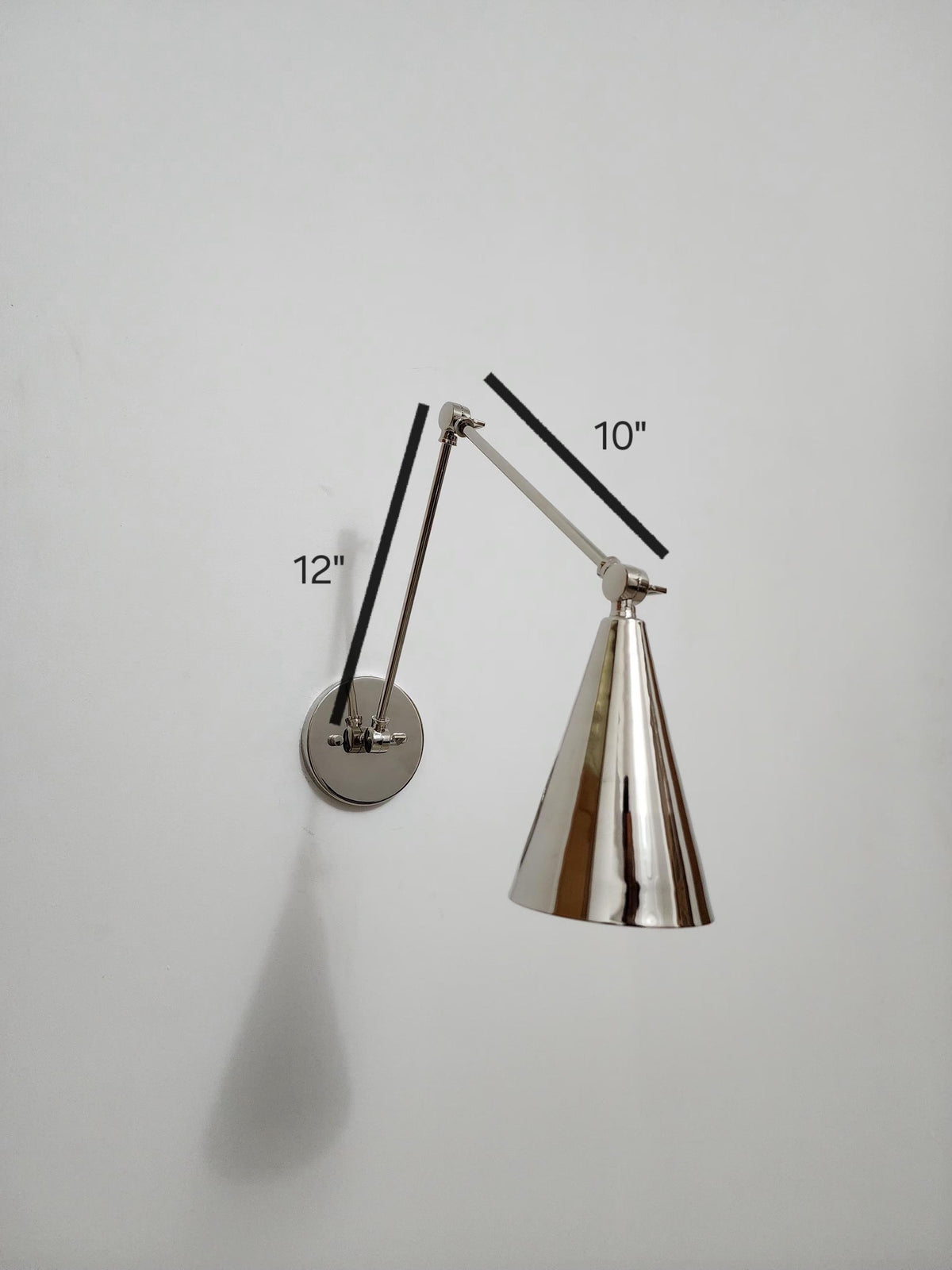 Brass and chrome adjustable wall sconce in mid-century style. Ember Lighting