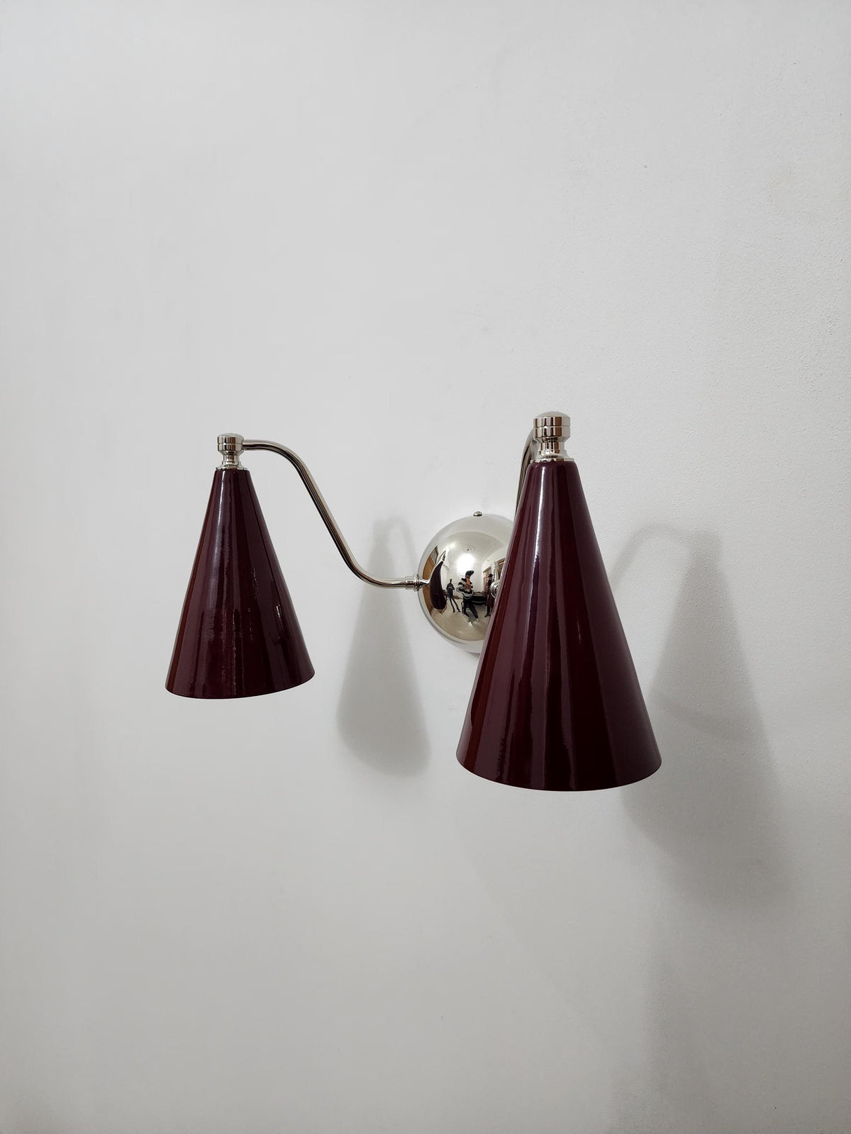 Contemporary design double cone brass sconce with wine shades. Ember Lighting