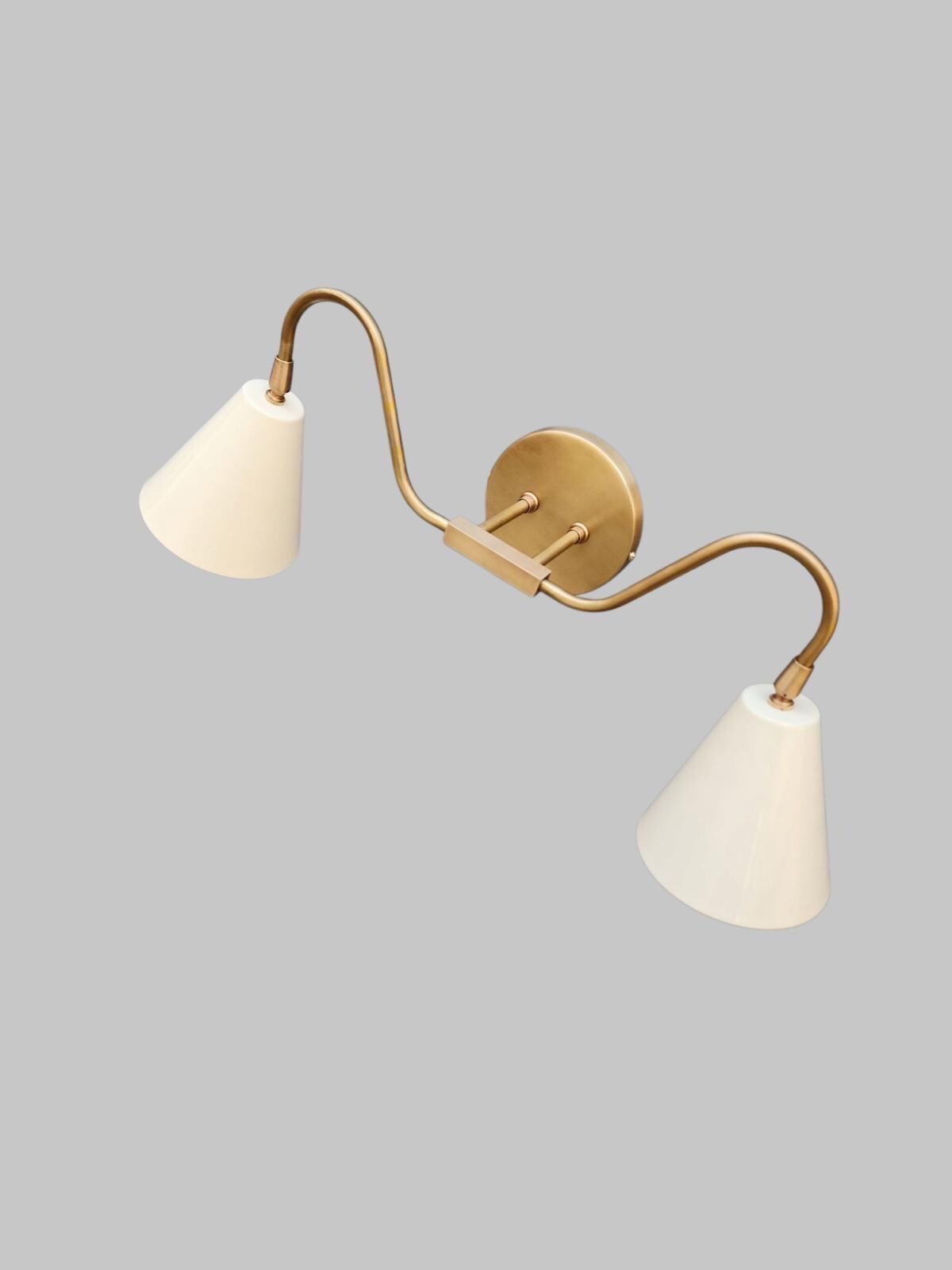 Double arm wall sconce crafted from brass in mid-century design. Ember Lighting