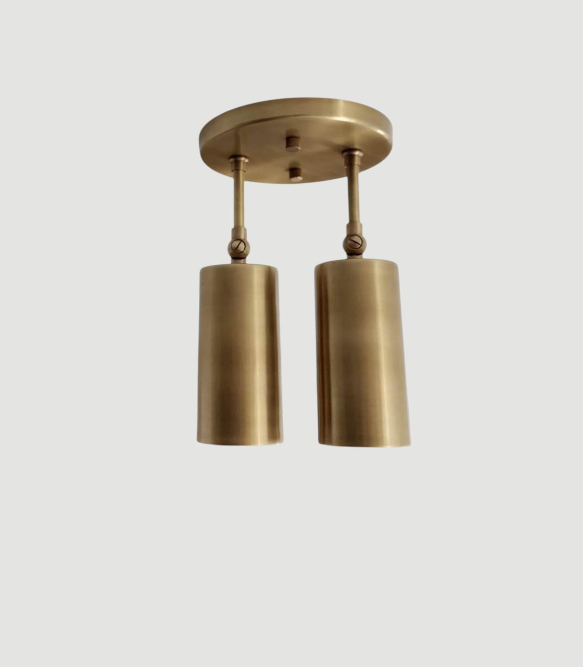 Dual cylindrical shades mounted ceiling light in brass. Ember Lighting
