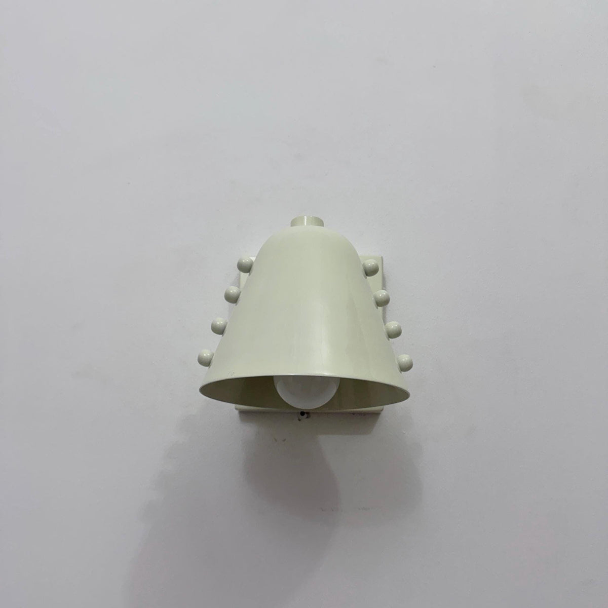 Elegant brass wall light with a stunning white cone shade. Ember Lighting