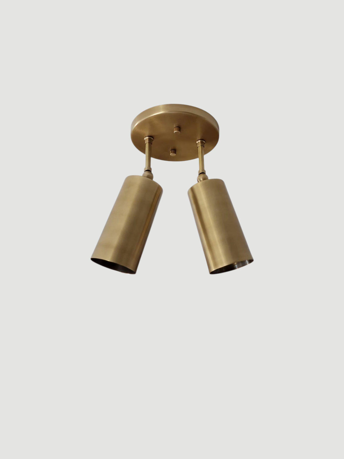 Elegant modern brass flush mount light with cylindrical shades. Ember Lighting