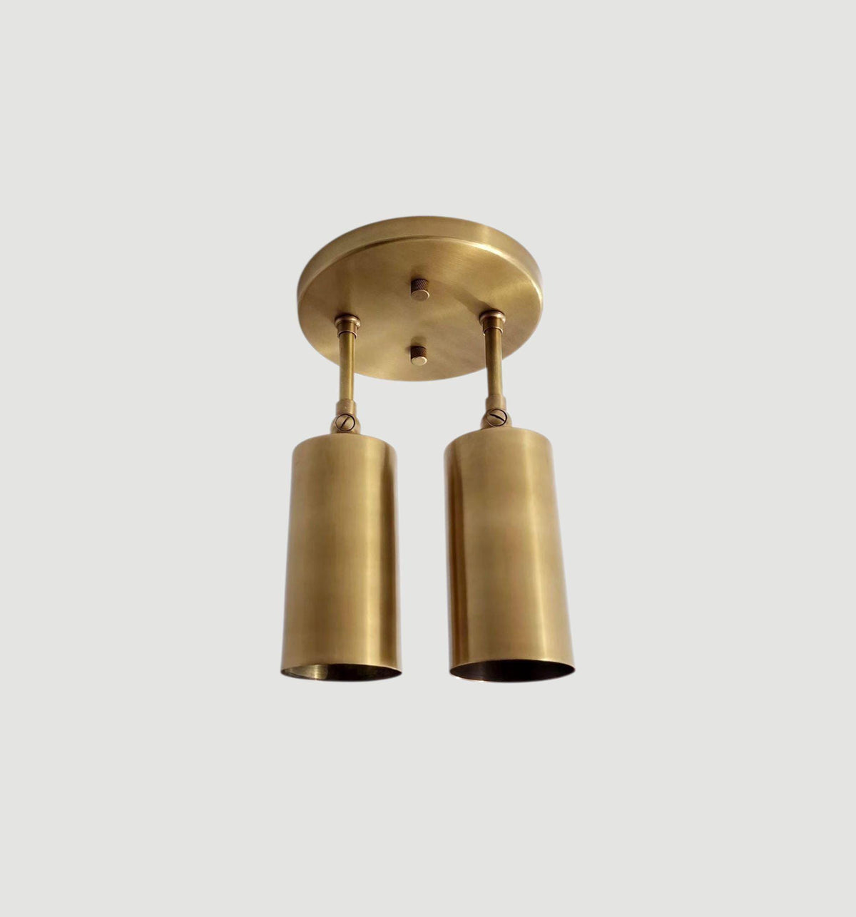 Handcrafted dual cylindrical shades in modern brass flush mount. Ember Lighting