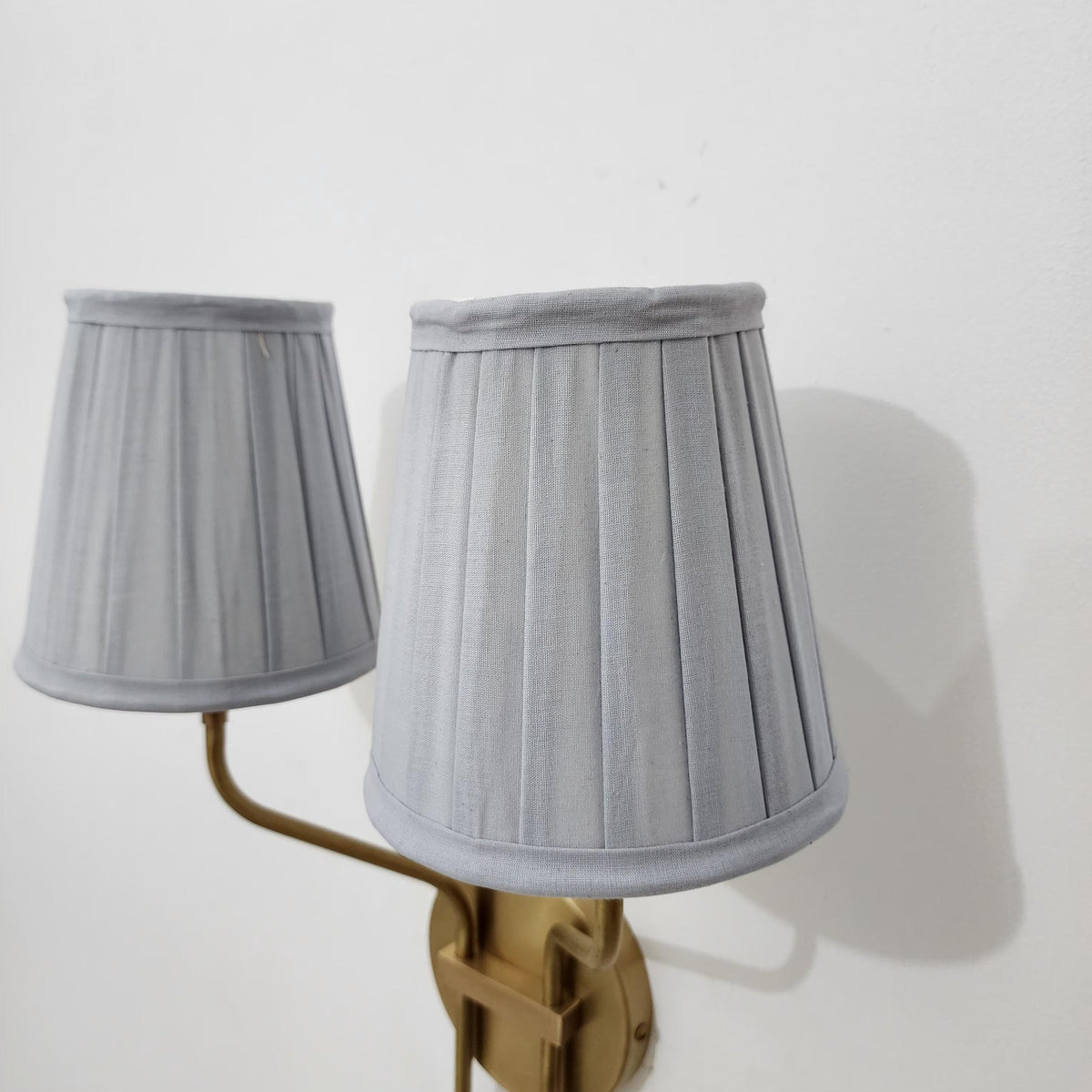 Double pleated shade brass wall sconce.