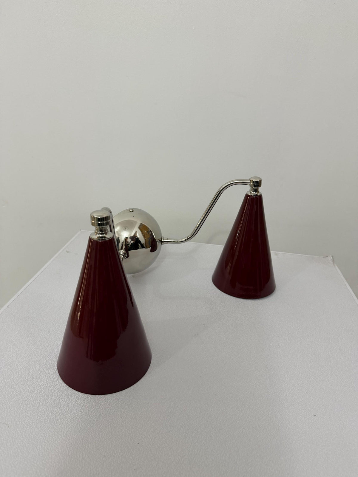 Mid-century brass sconce with double cone design and wine shades. Ember Lighting