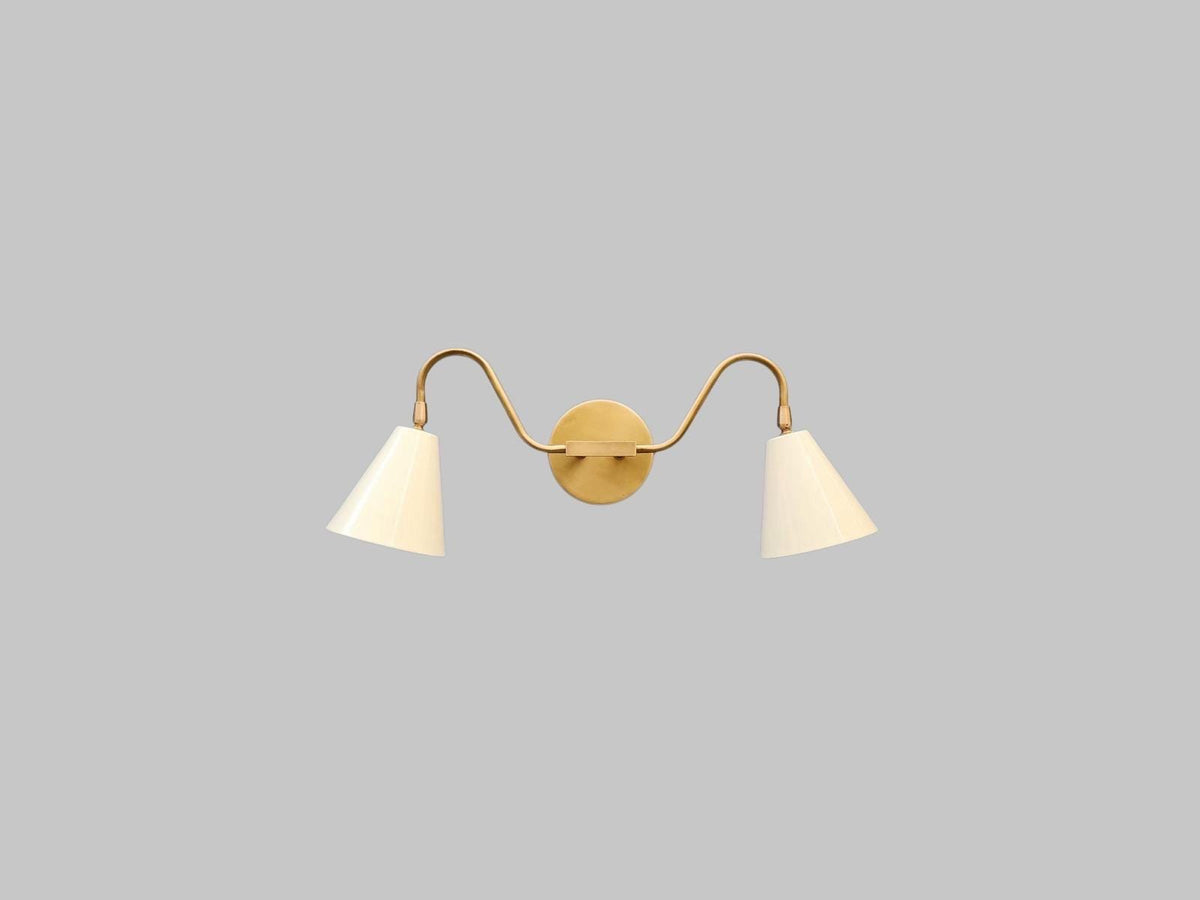 Mid-century modern double arm wall sconce crafted in brass. Ember Lighting