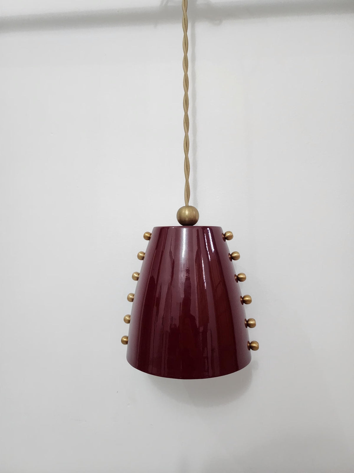 Mid-century style raw brass pendant with bold cone shade. Ember Lighting