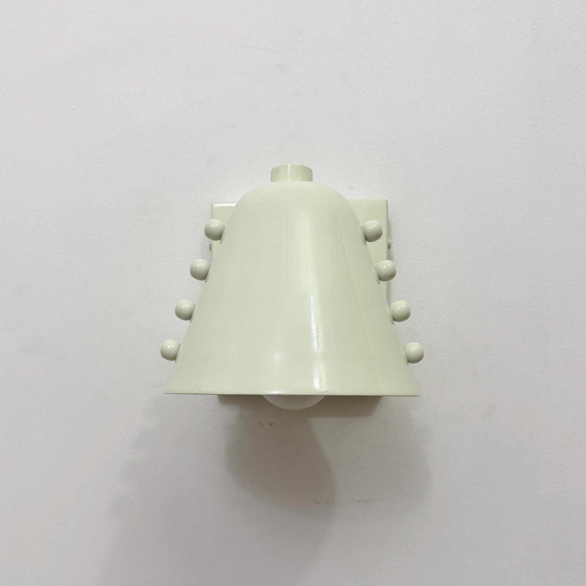 Minimal brass wall light fixture with a sleek white cone shade. Ember Lighting