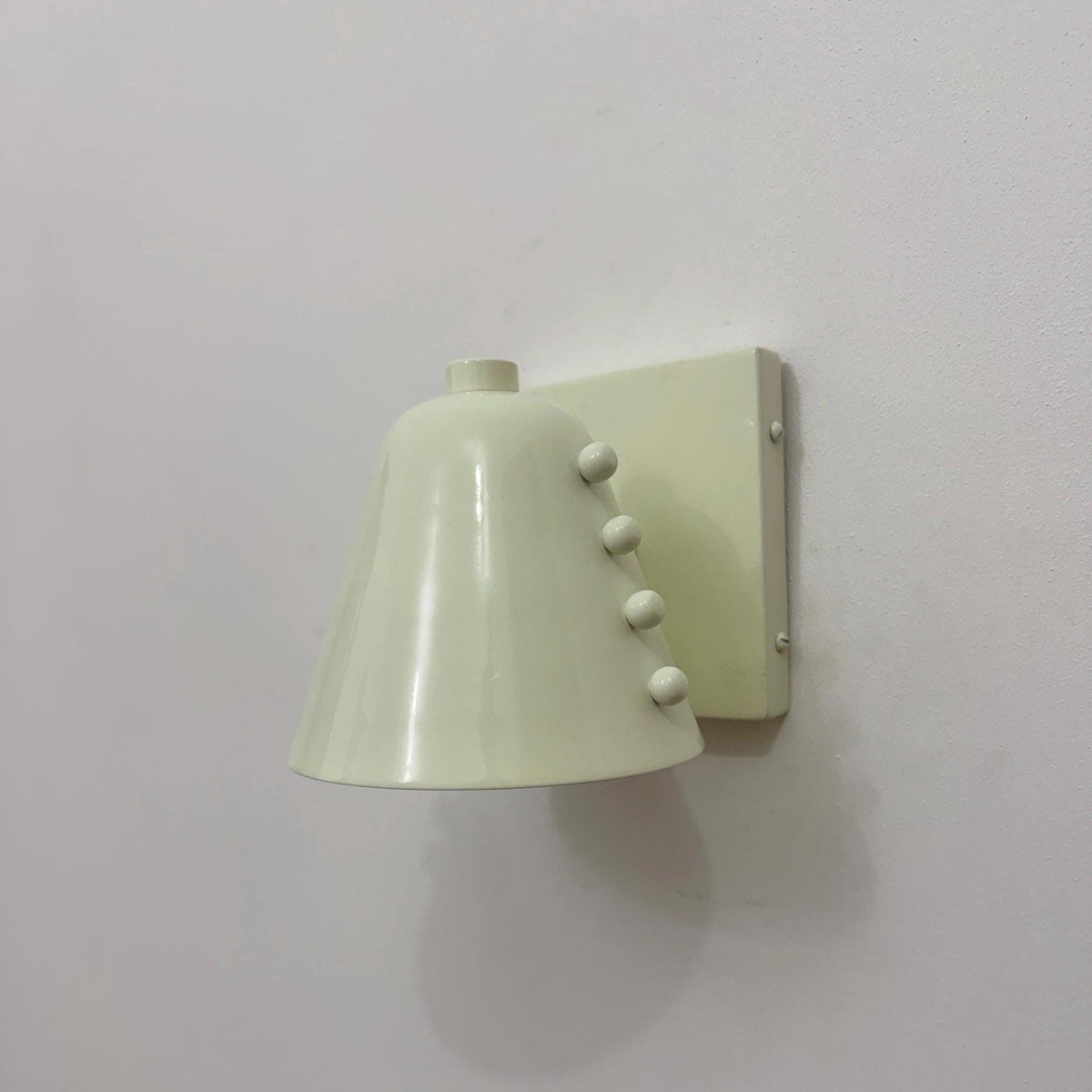 Minimalist brass wall light with white cone shade design. Ember Lighting