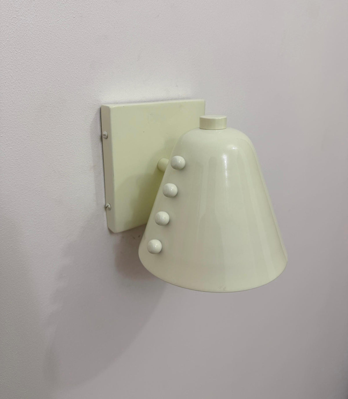 Modern wall light fixture in brass with white cone shade. Ember Lighting