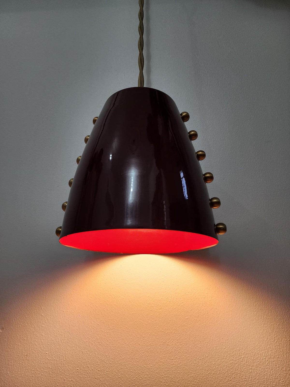 Raw brass mid-century pendant light with bold cone shade. Ember Lighting