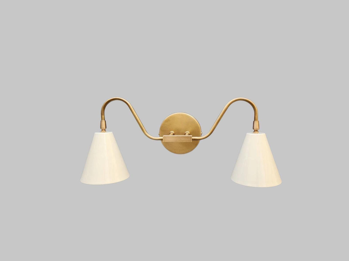 Stylish mid-century modern double arm wall sconce in brass. Ember Lighting