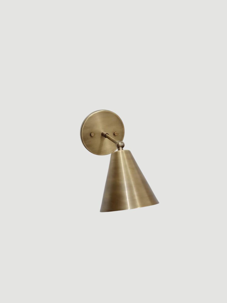 Stylish vintage brass adjustable wall sconce with cone light.