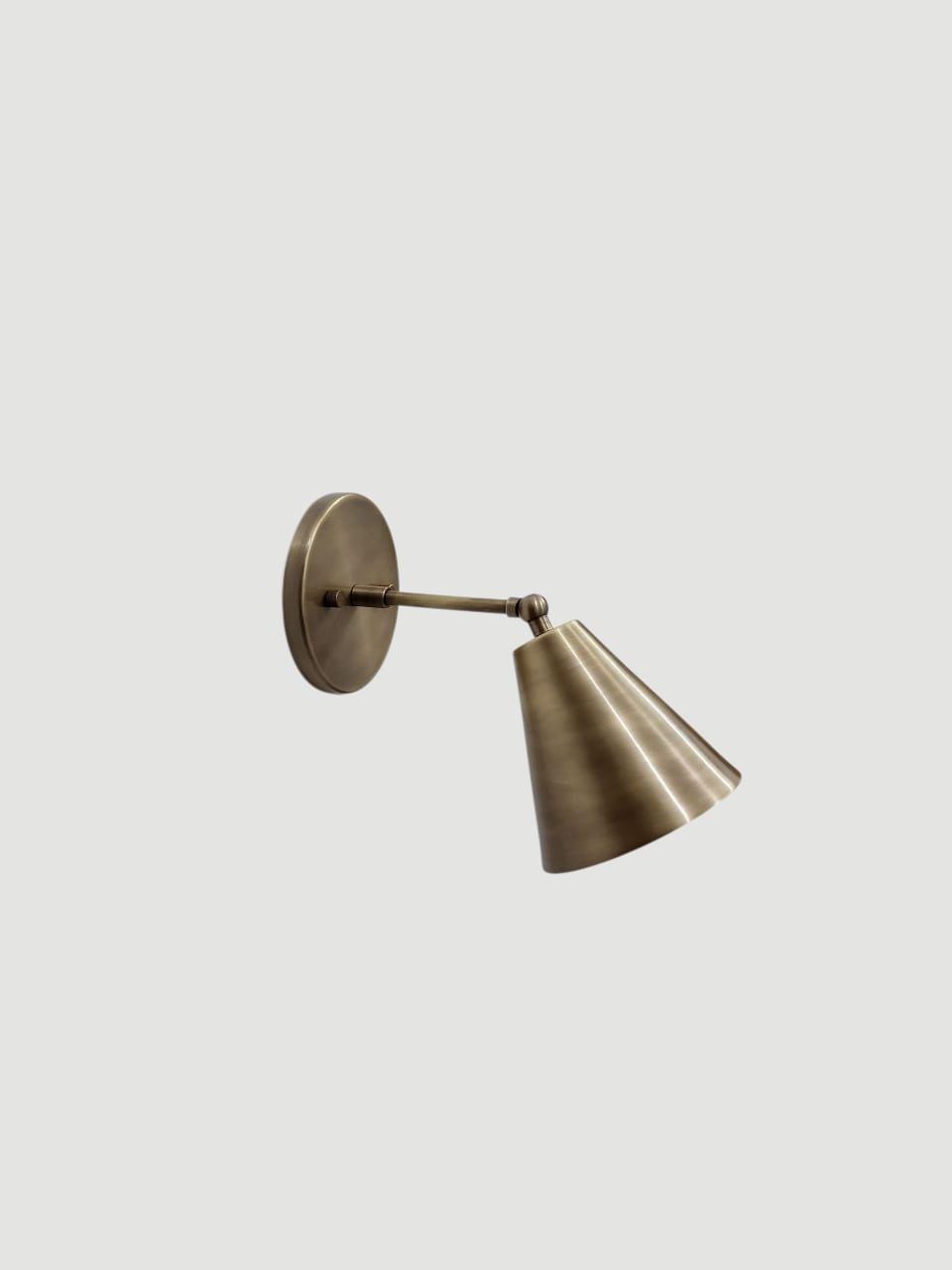 Vintage brass adjustable wall sconce with a cone-shaped shade.