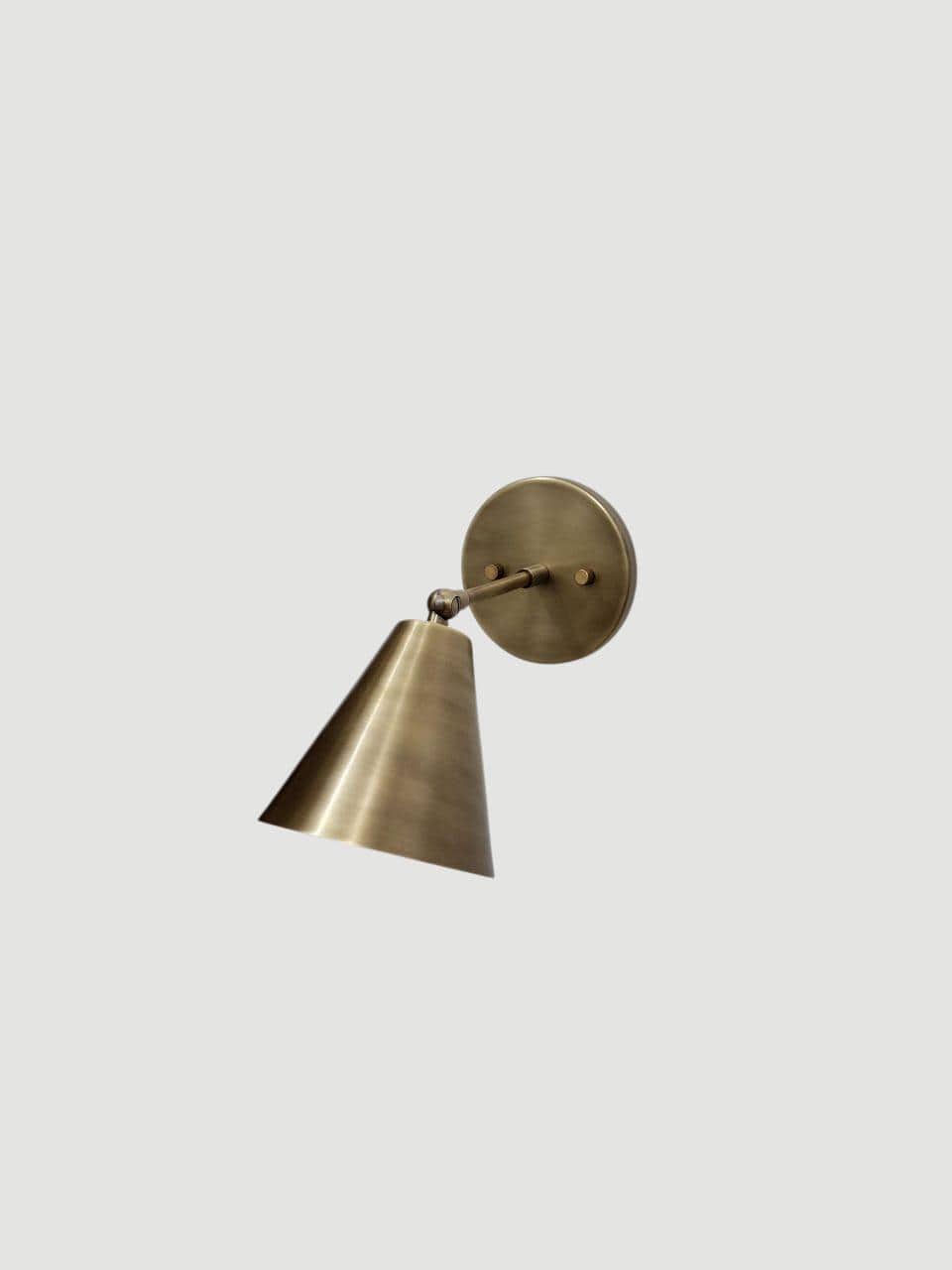 Vintage brass adjustable wall sconce with handcrafted cone light.